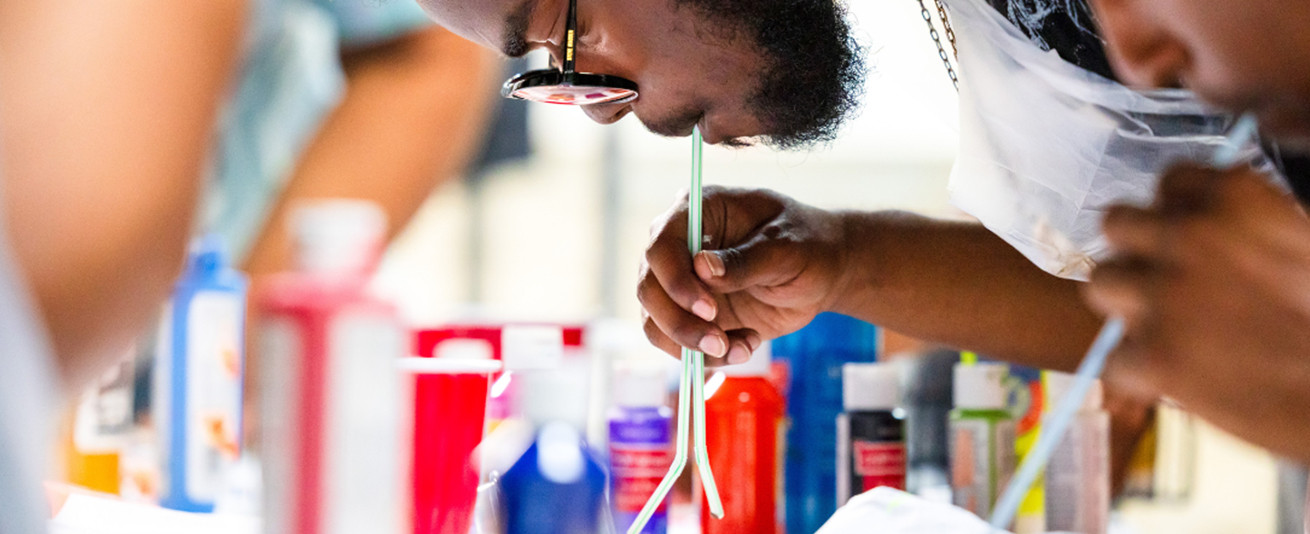 photo of Honey Art Studio student blowing paint