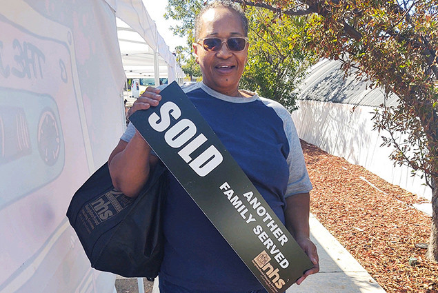 Photo of Doris Ealy holding NHS sign.