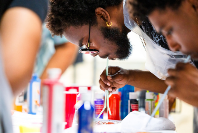 photo of students at Honey Art Studio blowing paing