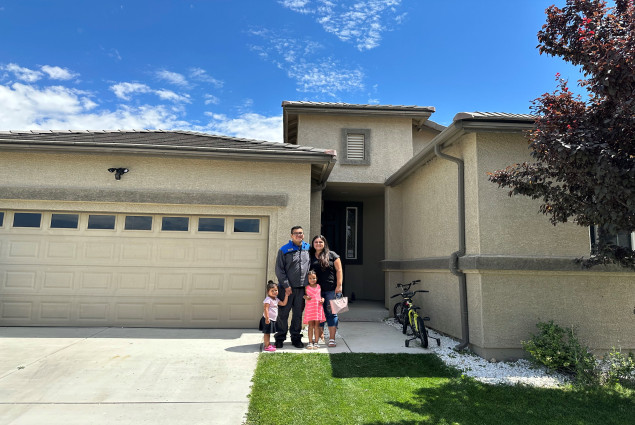 photo of Justina Yellowhair with her husband and two children in from of a home they purchased with a grant from FHLBank San Francisco