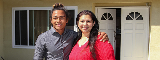 Photo of mother and son in front of their home