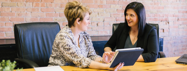 two women looking at tablet